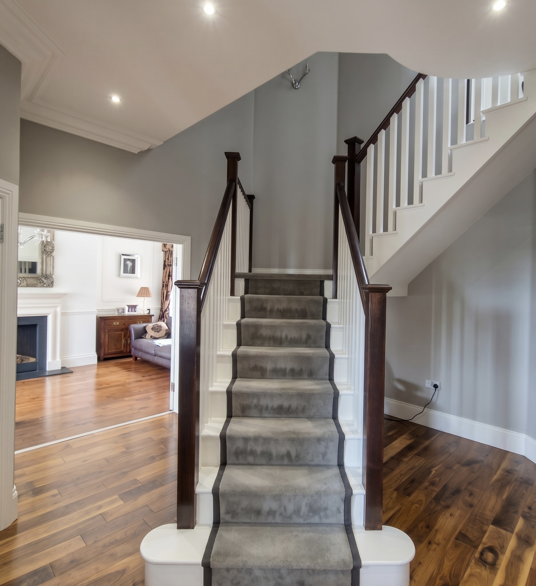 Grand staircase carpet runner dark wood handrail